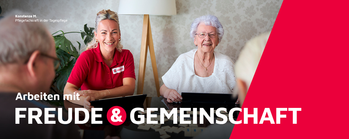 Eine Pflegefachkraft in der Tagespflege beim Spielen mit Klienten.